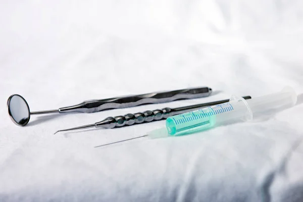 Diş hekimleri ayna ve şırıngayı kapatır. 