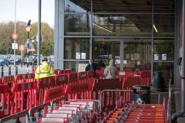 Gravesend, Kent, İngiltere - Mart 12019 Süpermarketin dışında güvenlik personelinin alışveriş engellerini hazırladığını gösteriyor