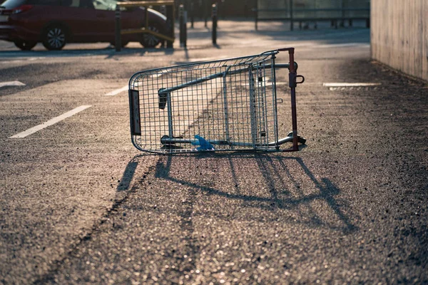 Tek kullanımlık mavi eldiveni olan terk edilmiş bir süpermarket arabası.