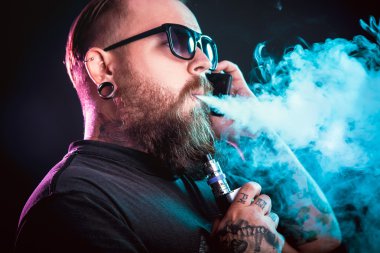 Güneş gözlüğü vaping sakallı adam