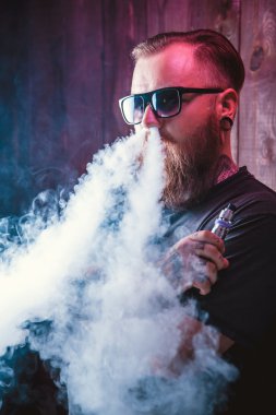 Güneş gözlüğü vaping sakallı adam