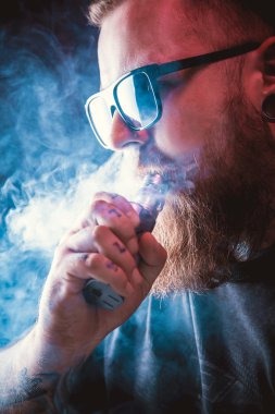 Güneş gözlüğü vaping sakallı adam