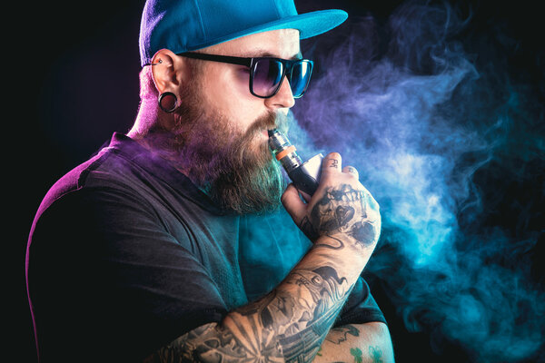 Man with beard  in sunglasses vaping