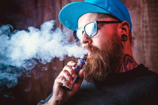 Man with beard  in sunglasses vaping — Stock Photo, Image