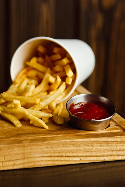 Verse frites met ketchup op houten ondergrond — Stockfoto