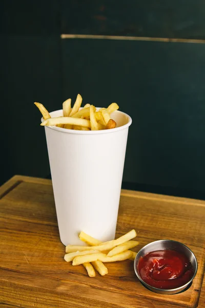 Verse frites met ketchup op houten ondergrond — Stockfoto