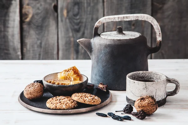 Keramische theepot met een kopje thee en koekjes — Stockfoto