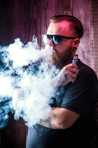 Hombre con barba en gafas de sol vaping — Foto de Stock