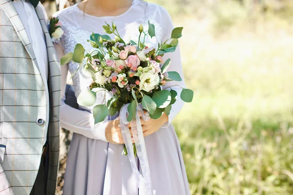 Ursprungliga bukett blommor i händerna på flickan — Stockfoto