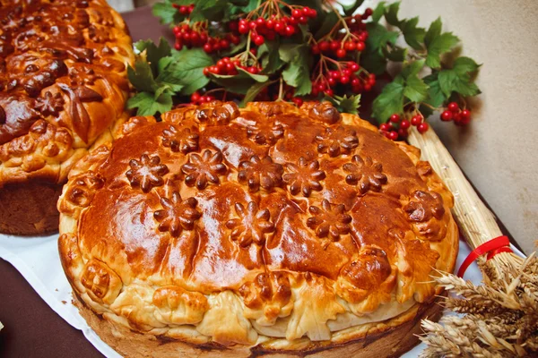 A nice loaf with viburnum berries and ears of wheat — Stock Photo, Image