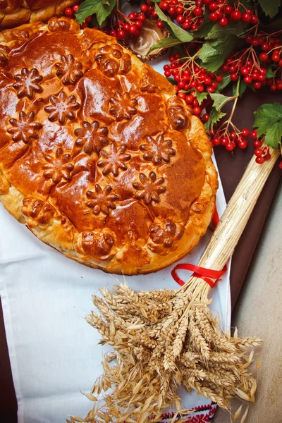 A nice loaf with viburnum berries and ears of wheat — Stock Photo, Image