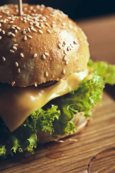 Hermosa hamburguesa sabrosa y apetitosa hamburguesa con queso sobre fondo de madera —  Fotos de Stock