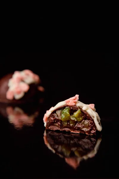 Красиві шоколадні цукерки з начинкою на чорному тлі — стокове фото