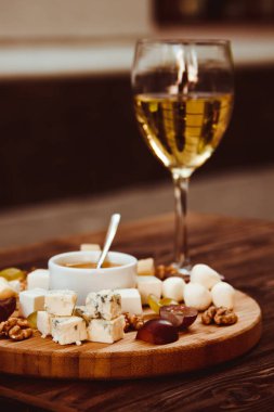 Üzüm, fındık ve ahşap arka plan üzerinde beyaz şarap ile peynir kurulunda görev yapmaktadır