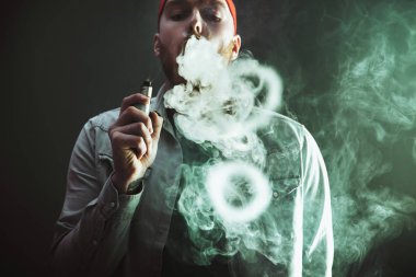 Erkekler Güneş gözlükleri vaping sakallı ve Buhar bulutu serbest bırakır. Erkekler Güneş gözlükleri vaping sakallı ve Buhar bulutu serbest bırakır.