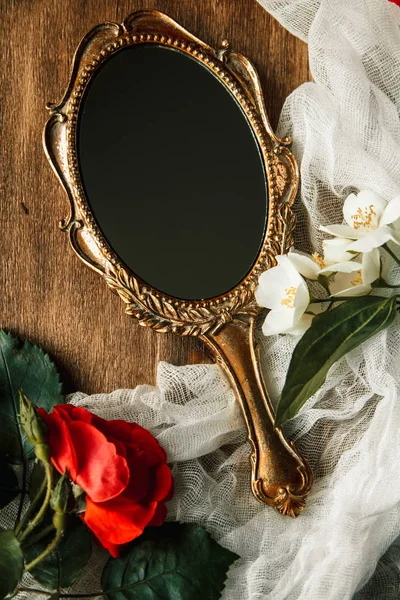 Mooie vintage spiegel met bloemen op houten achtergrond — Stockfoto