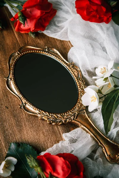 Beautiful a vintage mirror with flowers on wooden background — Stock Photo, Image