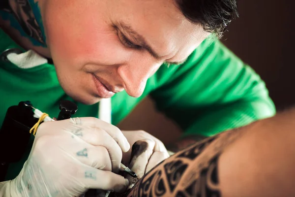 Mestre tatuador em luvas faz tatuagem na mão homens — Fotografia de Stock