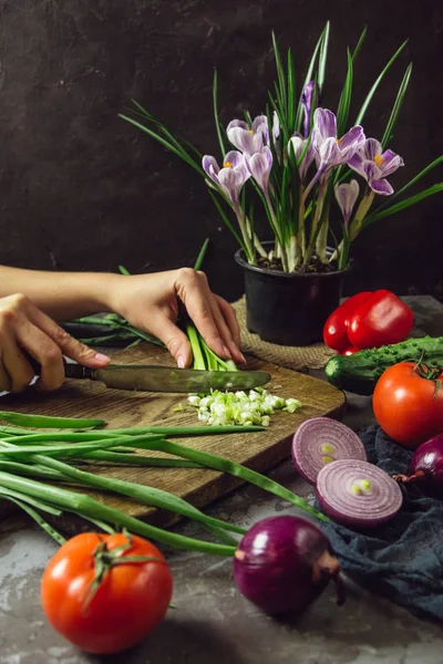 Jovem cozinhando na cozinha comida saudável, salada de legumes. Segurando uma faca e cortando legumes em uma tábua de corte. Estilo de vida saudável cozinhar em casa . — Fotografia de Stock