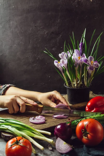 Jovem cozinhando na cozinha comida saudável, salada de legumes. Segurando uma faca e cortando legumes em uma tábua de corte. Estilo de vida saudável cozinhar em casa . — Fotografia de Stock