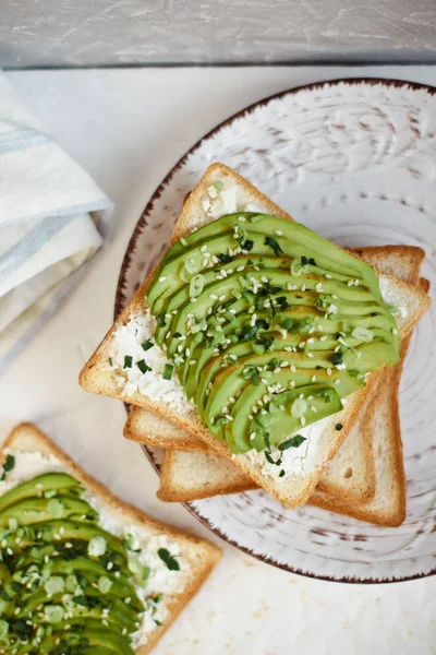 Avokado, beyaz peynir, otlar ve susam tohumu tost. Sağlıklı beslenme ve sağlıklı kahvaltı — Stok fotoğraf