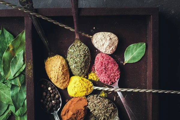 Mooie gekleurde kruiden in een zilveren lepel op een donkere achtergrond. Het concept van het koken, gezond eten — Stockfoto