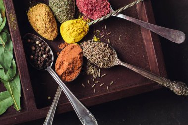 İçinde karanlık bir arka plan üzerinde varlıklı bir güzel renkli baharatlar. Yemek, sağlıklı gıda kavramı