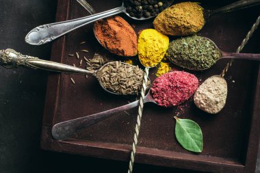 İçinde karanlık bir arka plan üzerinde varlıklı bir güzel renkli baharatlar. Yemek, sağlıklı gıda kavramı