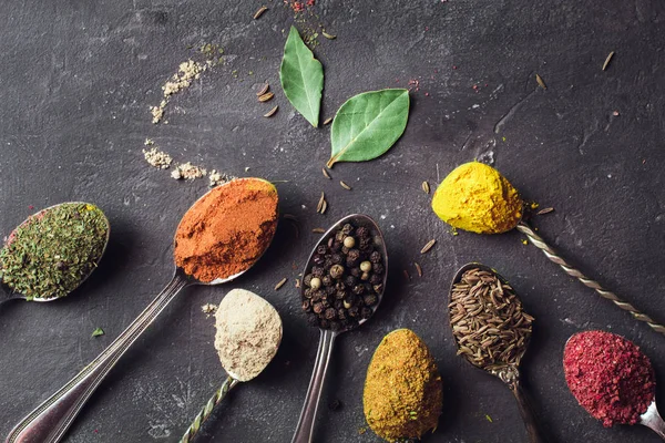 Mooie gekleurde kruiden in een zilveren lepel op een donkere achtergrond. Het concept van het koken, gezond eten — Stockfoto