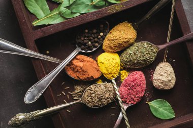 İçinde karanlık bir arka plan üzerinde varlıklı bir güzel renkli baharatlar. Yemek, sağlıklı gıda kavramı