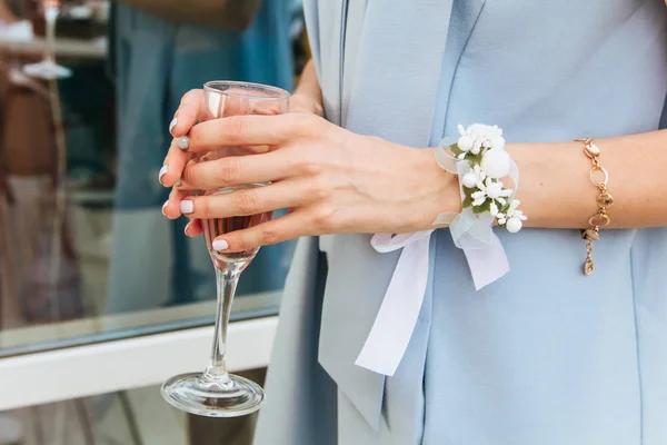 Braut im Kleid mit Boutonniere hält ein Glas Champagner — Stockfoto