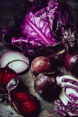Güzel koyu arka plan ile meyve ve sebze bir renk: mavi lahana, pancar, soğan, fesleğen, Erik