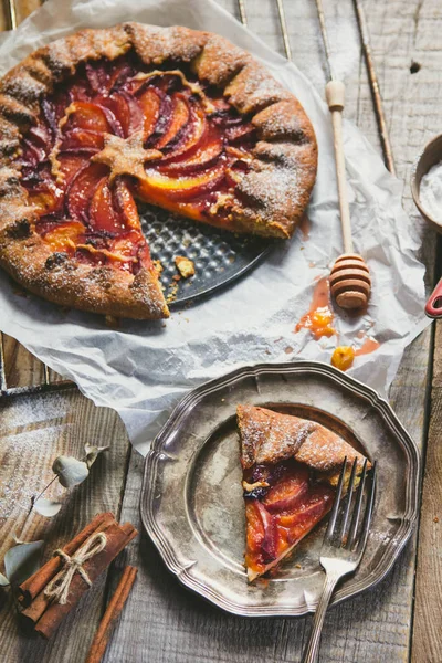 Galette with peaches on the old wooden background. Beautiful sweet cake background — Stock Photo, Image