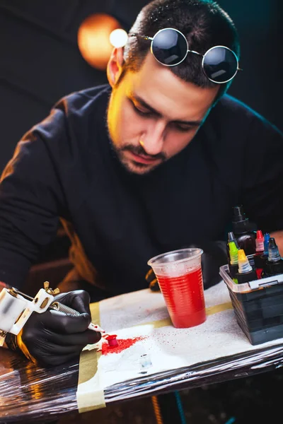 Художник готовит инструменты для татуировки — стоковое фото