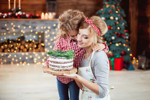 Madre e hija sosteniendo un pastel — Foto de Stock