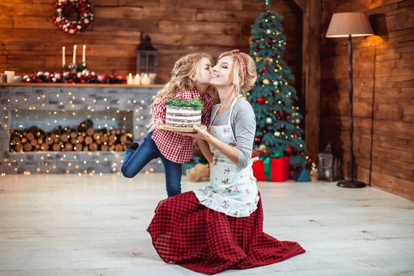 Moeder en dochter houden een taart — Stockfoto