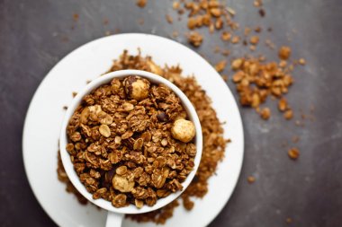 Granola gri tablo arka plan üzerinde beyaz Kupası'nda. Sağlıklı beslenme kavramı