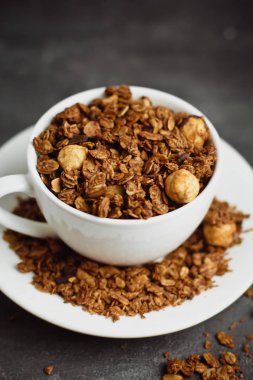 Granola gri tablo arka plan üzerinde beyaz Kupası'nda. Sağlıklı beslenme kavramı