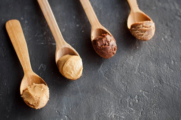 Holzlöffel Mit Erdnussbutter Auf Dunklem Tischhintergrund Stockfoto