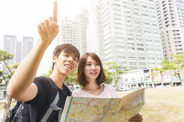 Happy tourists sightseeing city with map