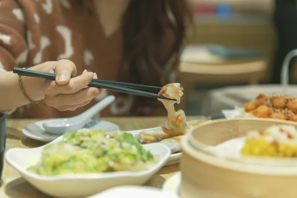 Asian woman eating Hong Kong cuisine in restaurant