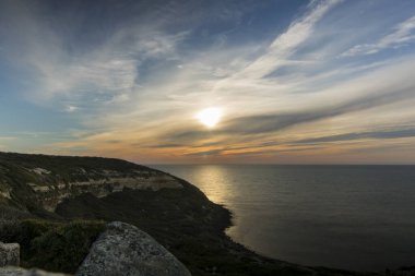 İtalya 'nın Sardegna adasında San Marco Burnu' nu uzun pozlu bir resimde gösteren gün batımı manzarası