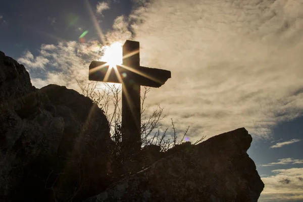 石クリスチャンは山を越えて太陽の隣を横断します ストックフォト
