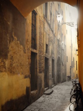 Arka ışıklandırması ve bisikleti olan bir sokak.