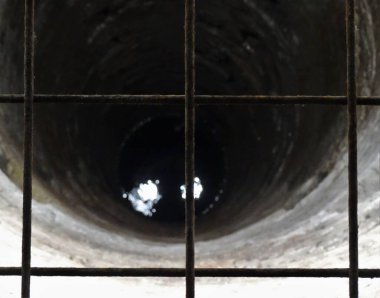 Su kuyusu manzarası ve ön planda bir ızgara