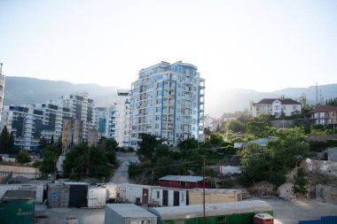 Küçük ve eski bir apartman ve inşaat alanının yakınındaki yeni uzun apartman binası. mavi gökyüzü