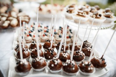 Krema ve böğürtlenlerle süslenmiş bir sürü kek.