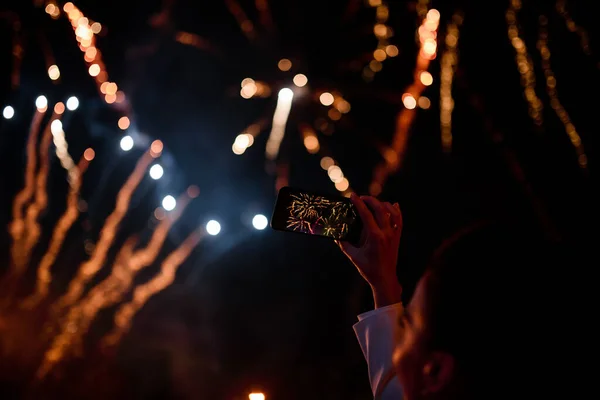 新しいスマートフォンで花火に写真を撮る女性の手 — ストック写真