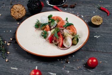 Gri servis masasında taze organik salata. Geleneksel yemek menüsü bir restoranda servis edilir