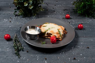 Gri masadaki lazanya. Geleneksel yemek menüsü bir restoranda servis edilir